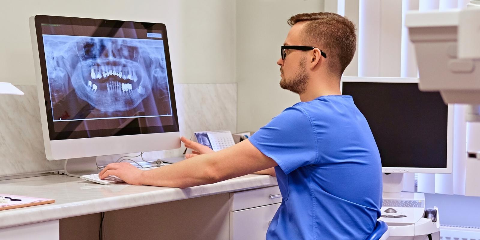 Tannlege ser på røntgenbilder på datamaskin.jpg